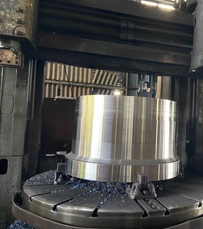 Machining shop floor — vertical lathe machining a forged wheel, 3,400 kg piece